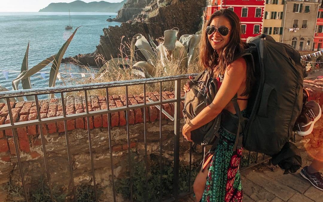 backpacker - girl wearing traveling backpack in cinque terre italy