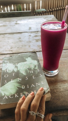 solo travel - girl reading a book and drinking a smoothie in bali