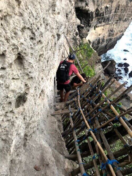 solo vacation - guys scaling down mountainside in nusa penida