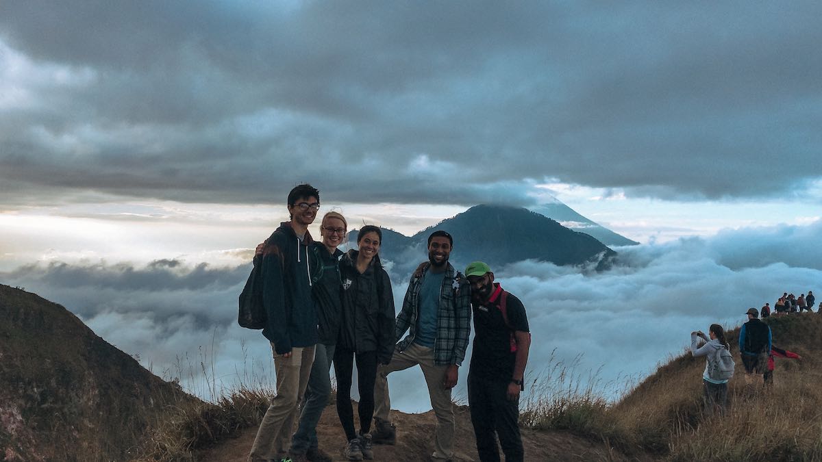 solo vacation - group posing on top of volcano above the clouds in bali