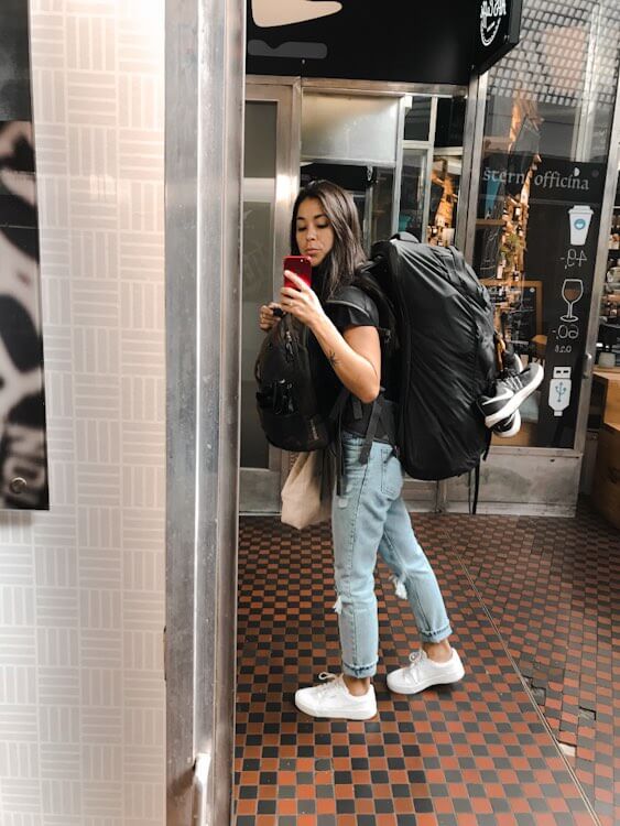 travel the world - girl wearing travel backpack posing in mirror