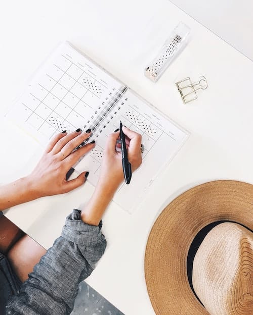 plan solo trip - girl writing in planner 