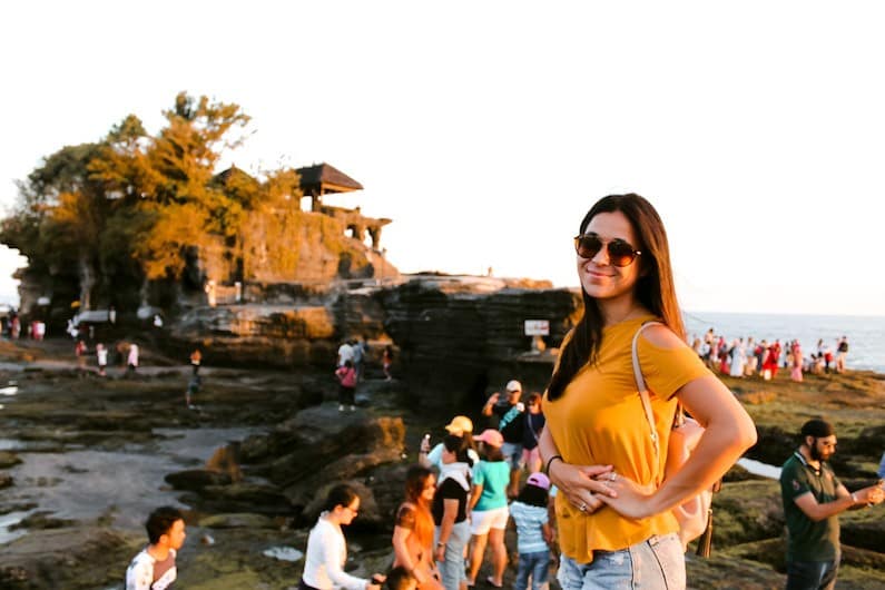 girl standing in front of tanah lot in canggu in bali on her first solo trip 