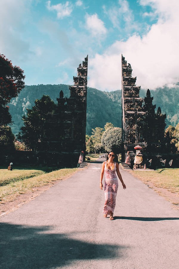 travel to bali - girl walking through arches in bali 